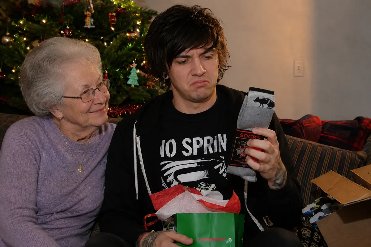 An unimpressed young man opening a pair of socks from his gran on Christmas morning